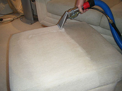 Upholstery cleaning tool on a cream fabric couch